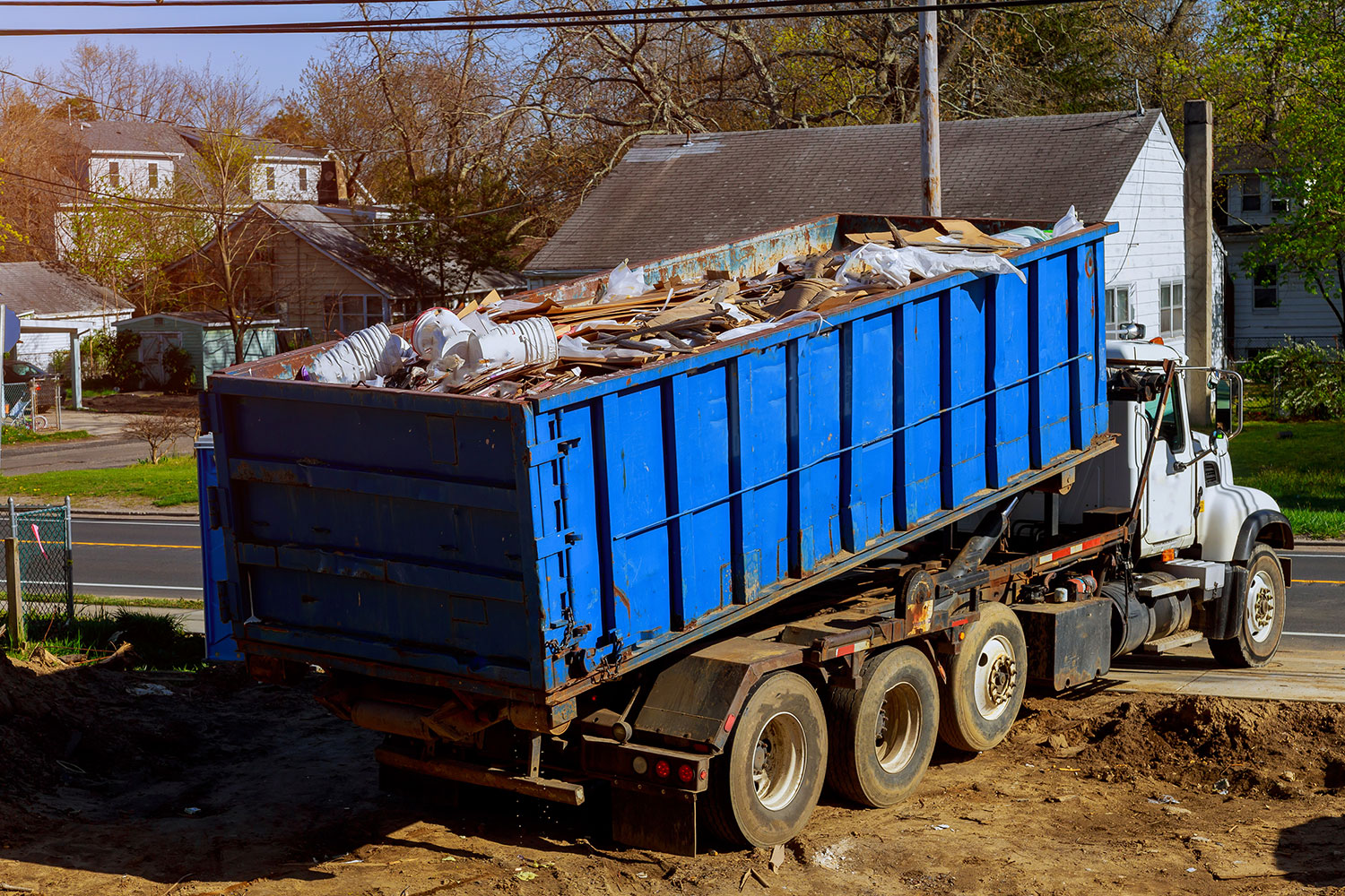 Roll-off truck hauling a construction debris dumpster